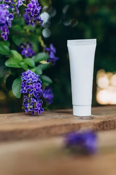 packaging mockup for a cream made from natural ingredients, on a background of purple flowers