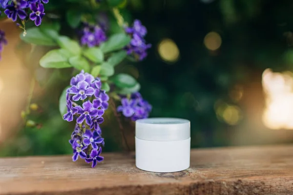 packaging mockup for a cream made from natural ingredients, on a background of purple flowers