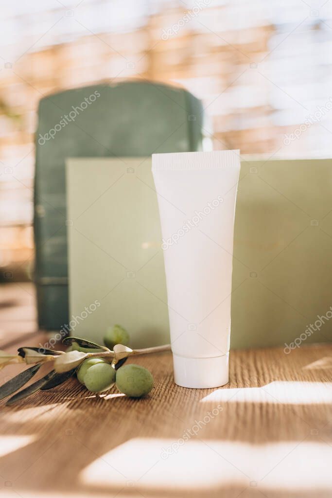 hand and face or body cream mockup on green background with olive branch