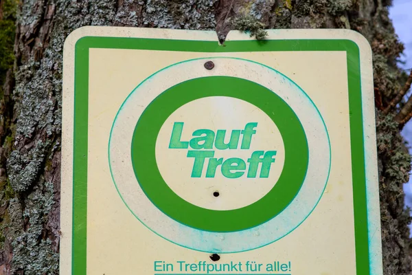 ドイツ語のテキスト Lauftreff で署名すると ランナーのための英語 ミーティングポイントに変換されます 誰にとっても出会いの場 — ストック写真