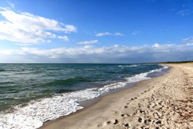 Deniz ve dalgalarla ıssız bir sahil.