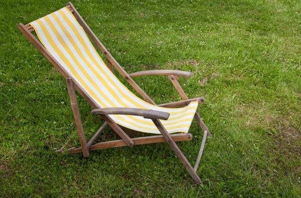 Çimlerin Üzerinde Eski Çizgili Katlanabilir Bahçe Sandalyesi — Stok fotoğraf