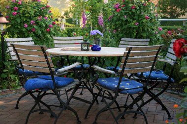 Tahta masa ve katlanabilir sandalyeler bahçede.