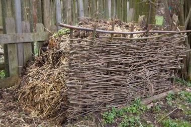 Rural dung heap behind a selfmade wooden fence