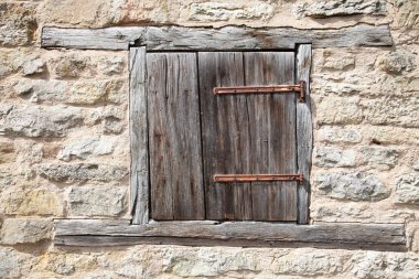 Kapalı eski yıpranmış kepenk taş bir duvarda