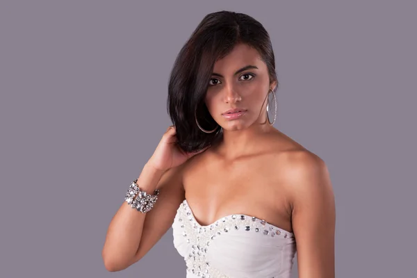 Schöne und sinnliche lateinamerikanische Frau, die ihr Haar hält und in die Kamera schaut — Stockfoto