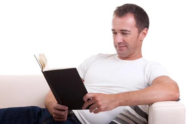 Μέσης ηλικίας άντρας ξαπλωμένος στον καναπέ ανάγνωση ενός βιβλίου — Φωτογραφία Αρχείου