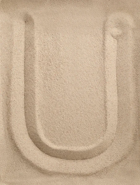 Буква U из песка — стоковое фото