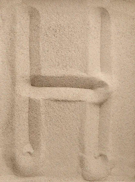Буква H из песка — стоковое фото