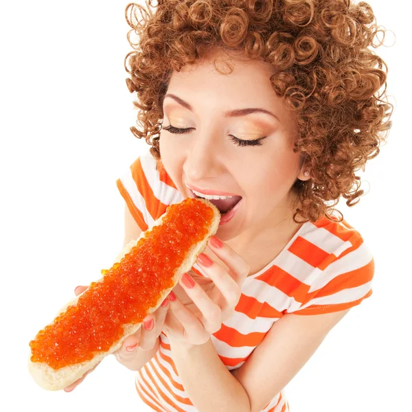 Fun woman eating the sandwich with red caviar on the white — Stock Photo, Image