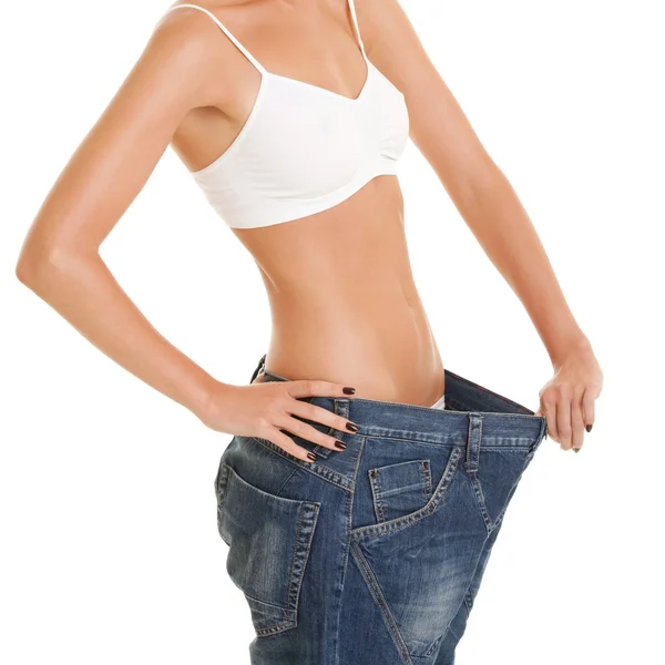 Funny woman shows her weight loss by wearing an old jeans, isola — Stock Photo, Image