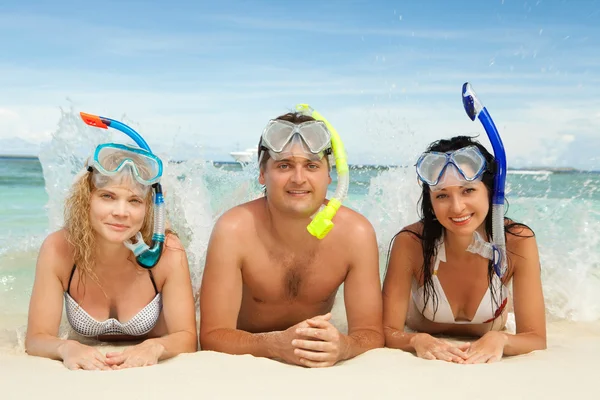 Amigos felizes com equipamento de snorkeling na praia — Fotografia de Stock