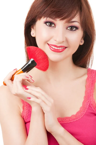 Mujer joven aplicando cepillo para maquillaje en su cara, aislado en w —  Fotos de Stock