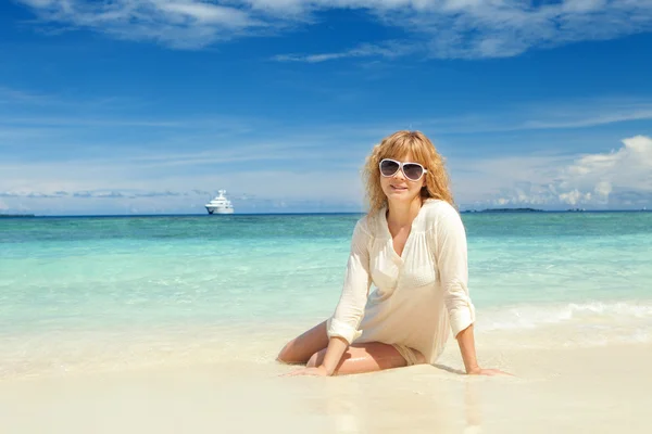 Glückliche junge Frau ruhen sich am Strand aus — Stockfoto