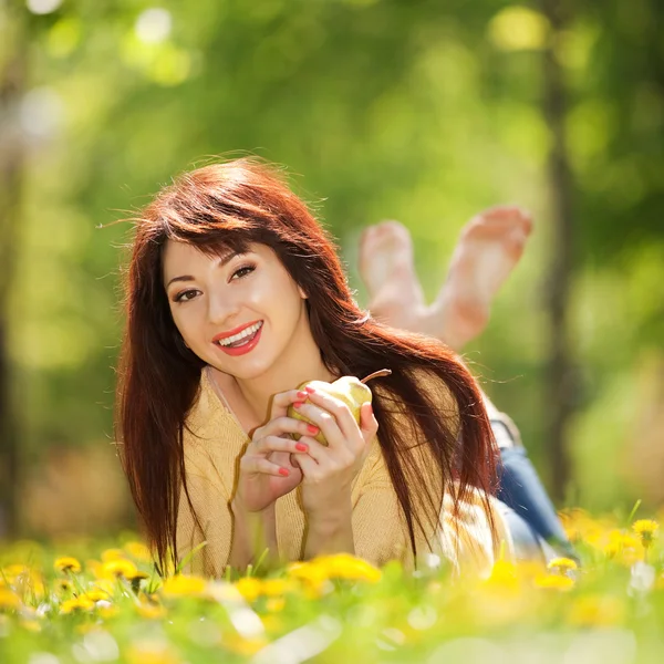 Happy woman with pear in the park — Stock Photo, Image