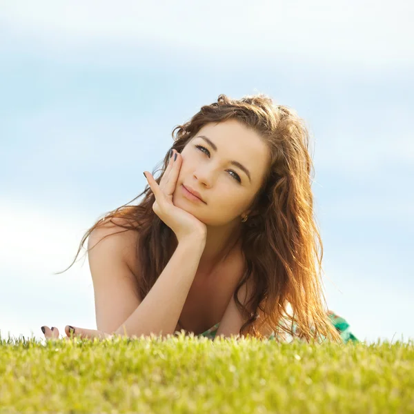Jovem mulher descansar na grama verde — Fotografia de Stock