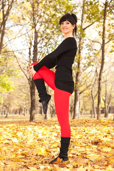Güzel bir kadın sonbahar Park spor egzersizleri yapıyor — Stok fotoğraf