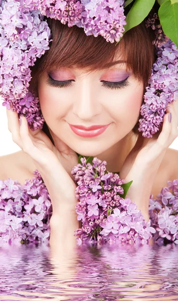 Young woman with lilac flowers in water — Stock Photo, Image