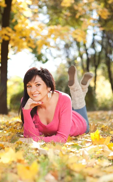 Giovane bella donna che riposa nel parco autunnale — Foto Stock