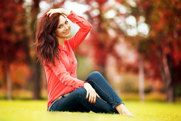 Giovane bella donna che riposa nel parco autunnale — Foto Stock