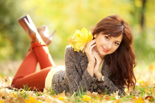 Giovane bella donna che riposa nel parco autunnale — Foto Stock