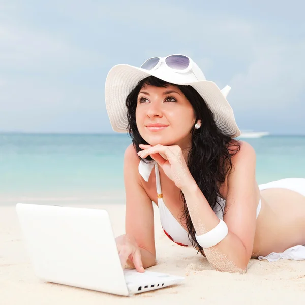 Мила жінка з білим ноутбуком на літньому пляжі — стокове фото