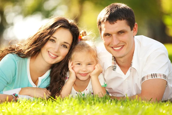 Madre felice, padre e figlia nel parco Foto Stock Royalty Free