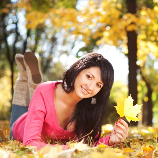 Sonbahar parkta oturan genç güzel kadın — Stok fotoğraf