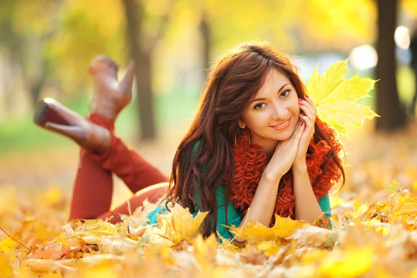 Giovane bella donna che riposa nel parco autunnale — Foto Stock