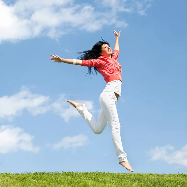 Jolie jeune femme sautant sur l'herbe verte — Photo