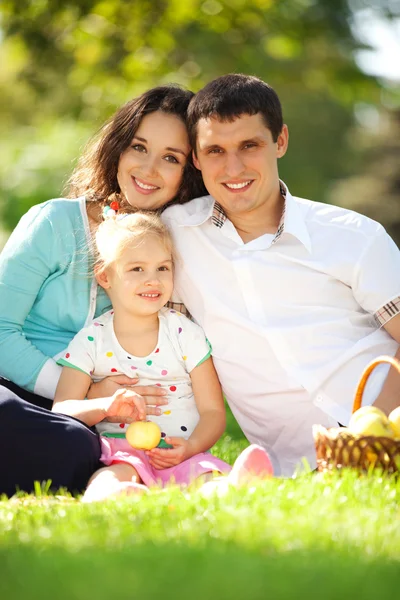 Met een picknick in de groene tuin en gelukkige familie — Stockfoto