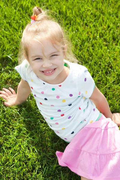 Yeşil çimenlerin üzerinde sevimli küçük kız — Stok fotoğraf