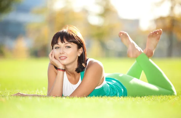 Happy young woman rest on the green grass — Stock Photo, Image