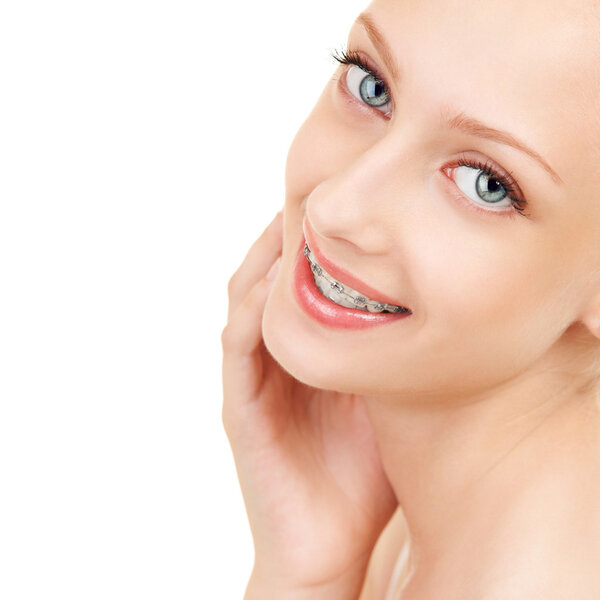Милая девушка в брекетах на белом фоне
