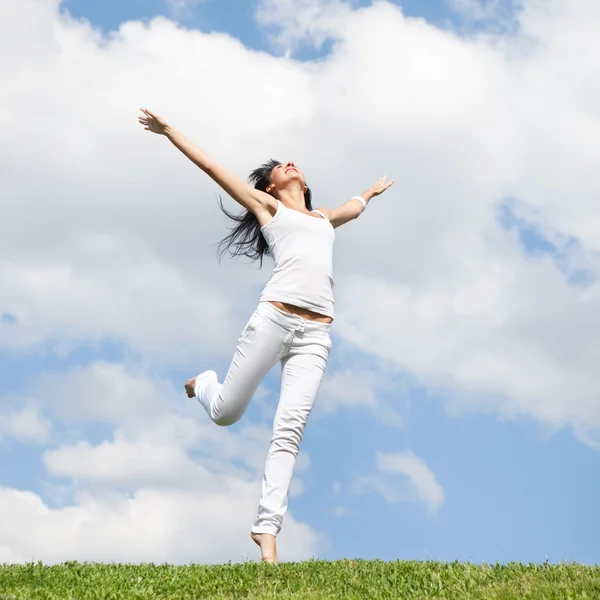 Красивая молодая женщина прыгает на зеленой траве — стоковое фото