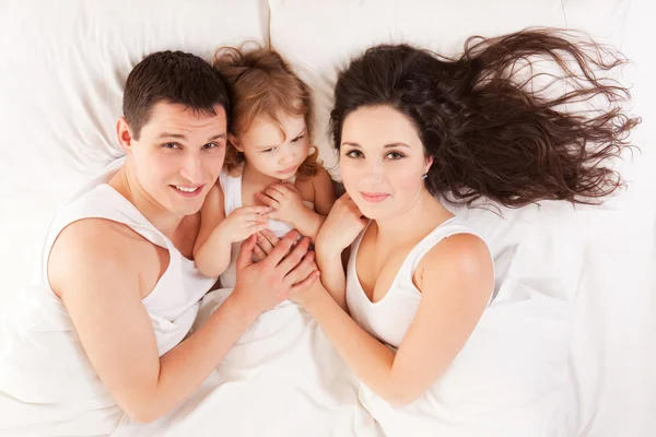 Happy family, mother, father and daughter resting on the white b — Stock Photo, Image