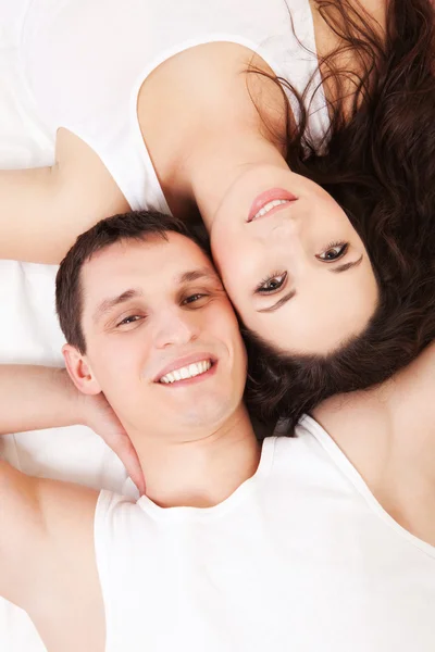 Young happy couple lying in the white bed — Stock Photo, Image