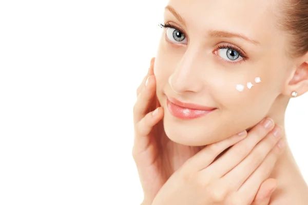 Mujer linda aplicando crema a su cara — Foto de Stock