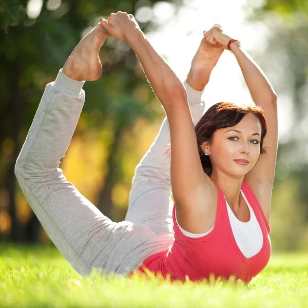 Parkta yoga egzersizi yapan güzel bir kadın. — Stok fotoğraf