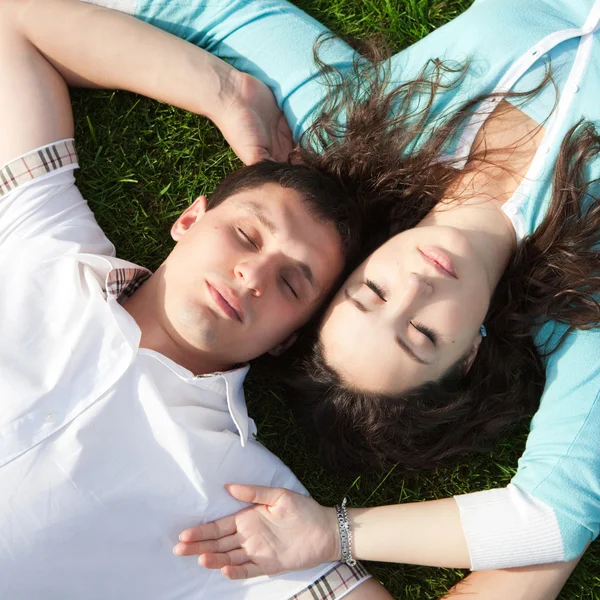 Happy couple relaxing on green grass — Stock Photo, Image