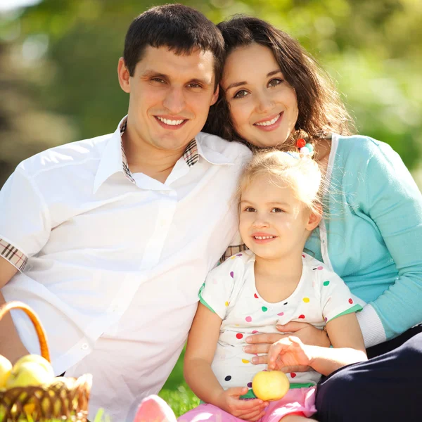 Familia feliz teniendo un picnic en el jardín verde —  Fotos de Stock