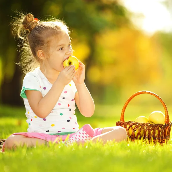 Linda niña comiendo manzana en el parque —  Fotos de Stock