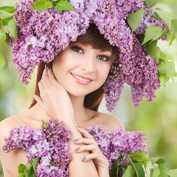 Jovem com flores lilás — Fotografia de Stock