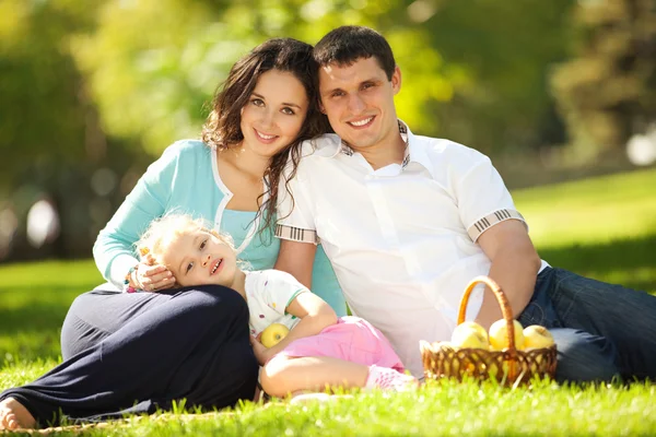 Happy family having a picnic in the green garden — Stock Photo, Image