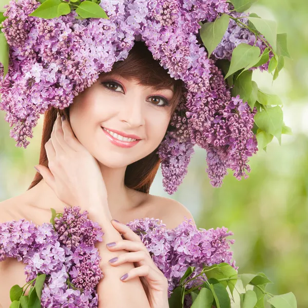 Jovem com flores lilás — Fotografia de Stock