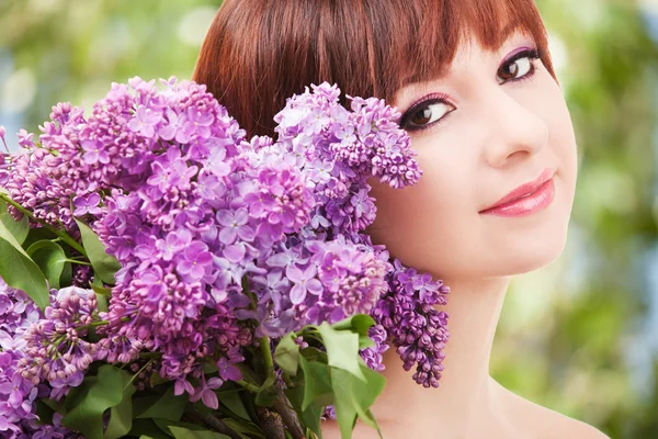 ライラック色の花を持つ若い女 — ストック写真