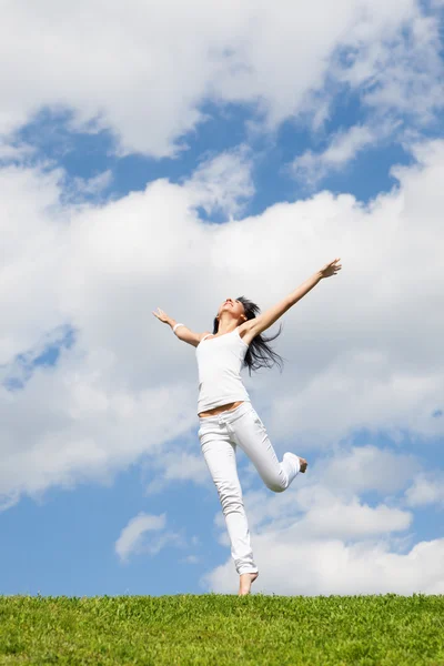 Pretty young woman jumping on green grass — Stock Photo, Image