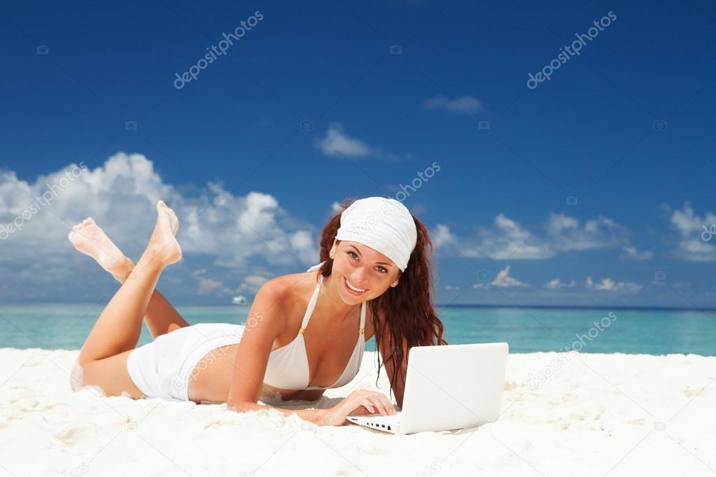 Cute woman with white laptop on the summer beach