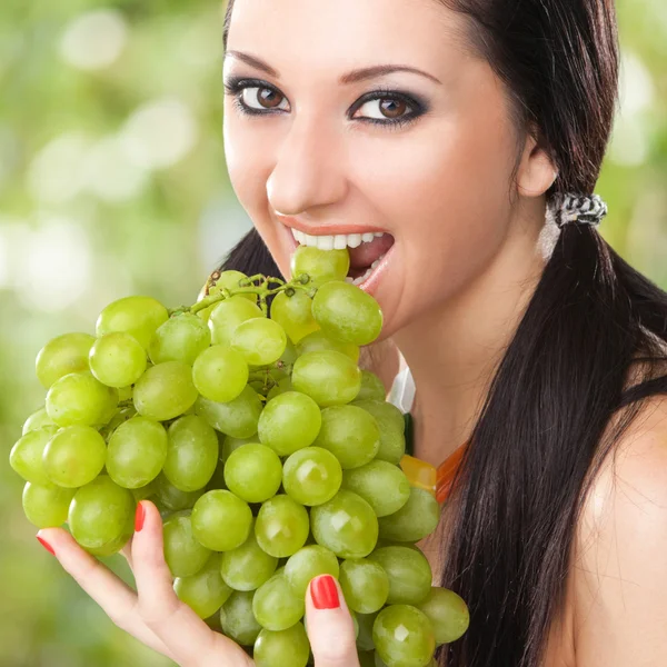 Bella donna con uva sullo sfondo verde — Foto Stock