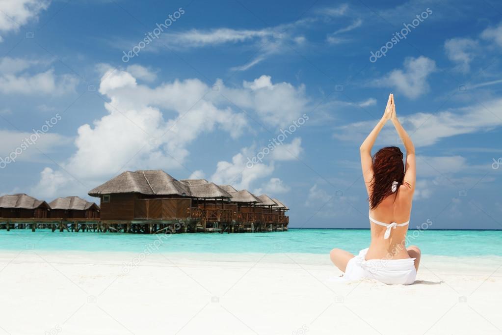 woman doing yoga exercises on the beach